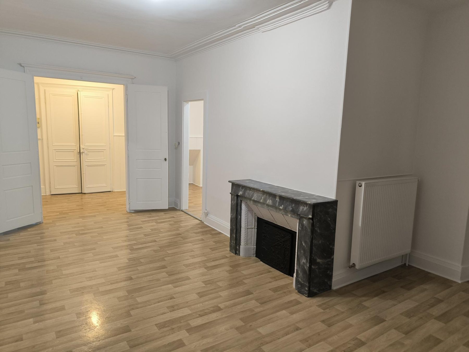 Pièce ancienne avec cheminée en marbre, corniches et doubles portes moulurées